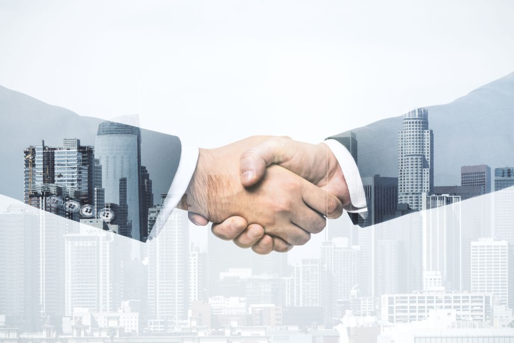 Handshake of two businessmen on modern cityscape background, deal and trading concept. Multiexposure